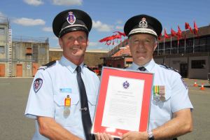 David Weir receiving his commendation from Commissioner Greg Mullins.