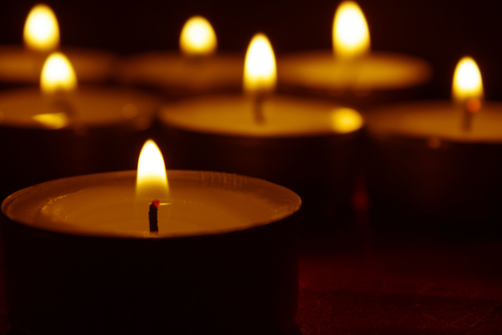 23174019 - burning candles and black background